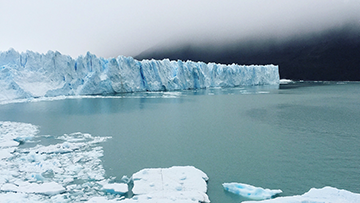 Mur de glace derrière des fragments de banquise flottant dans une baie du Nord du Canada.