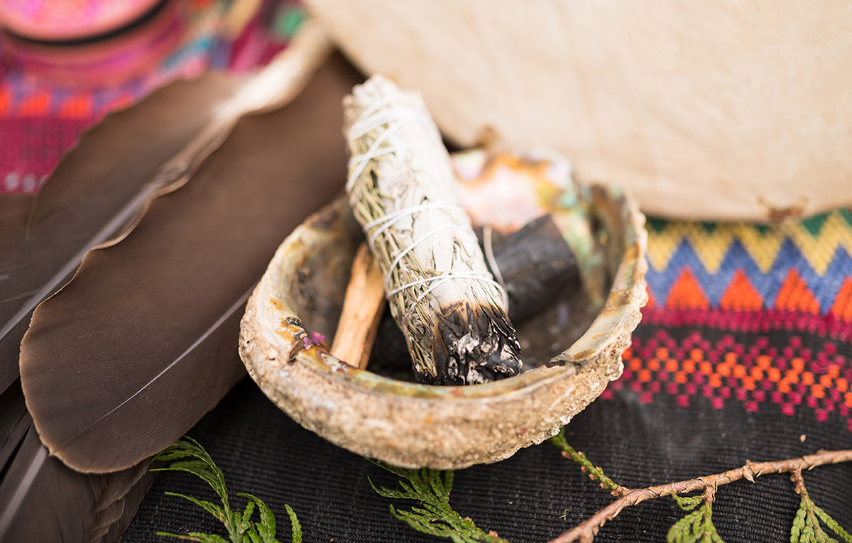 A bundle of sage and an eagle feather are laid out in preparation for an Indigenous smudging ceremony 