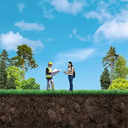 Two people standing in a field surrounded by trees and talking. One is male wearing a safety vest and holding a map. The other is female looking through a binder of notes.
They are in the planning stage of the pipeline lifecycle and are working together to plan a pipeline project.
