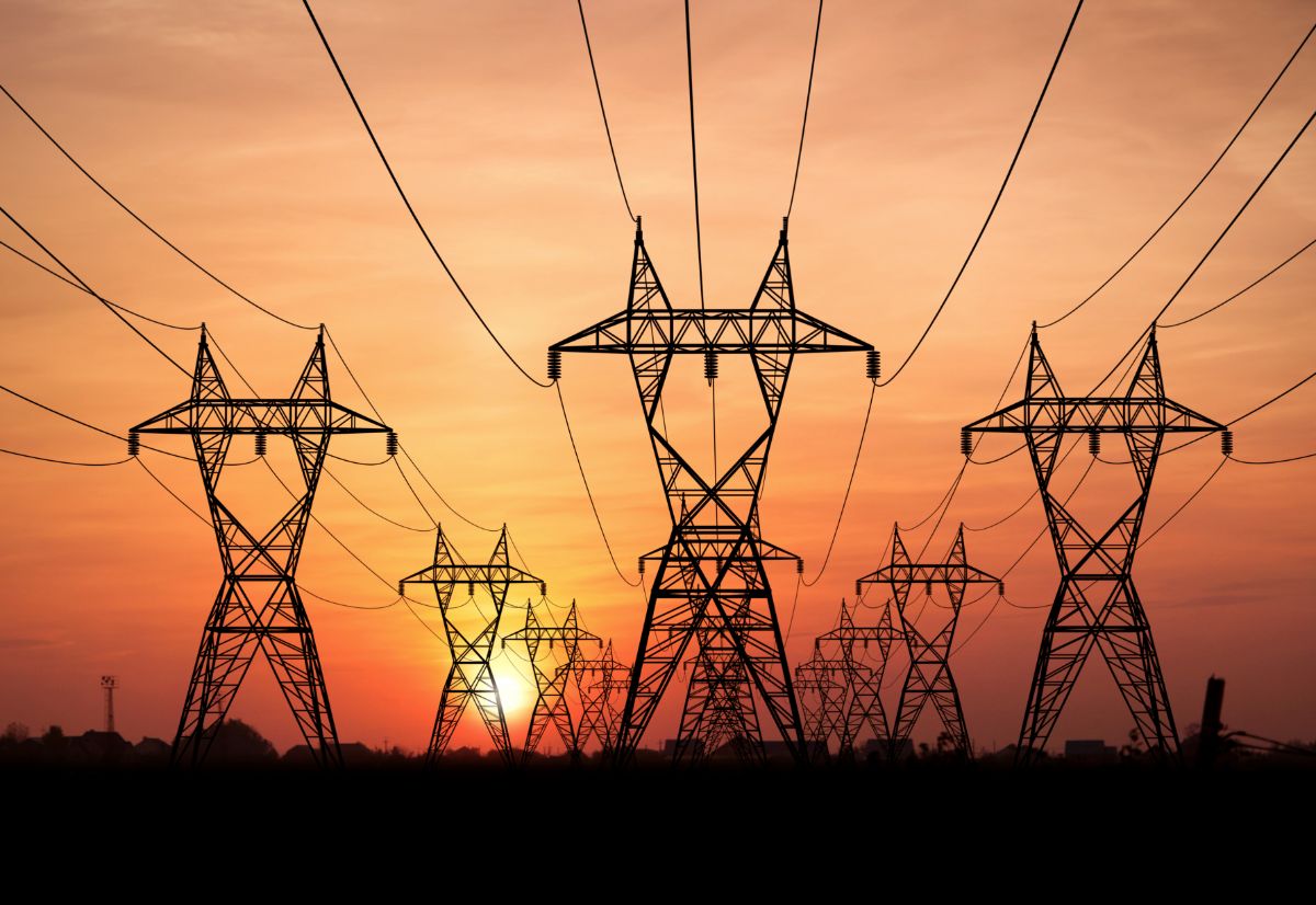 Electricity transmission towers and wires at sunset.