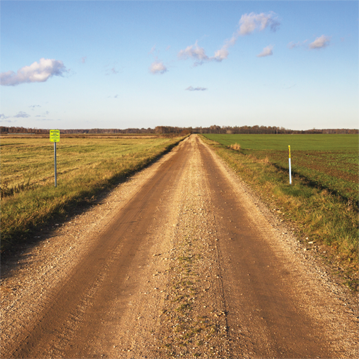 Dirt road with pipeline makers on both sides